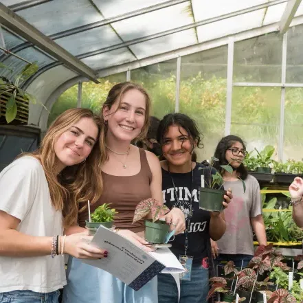 A group of students pick out their first-year plants in the greenhouse.